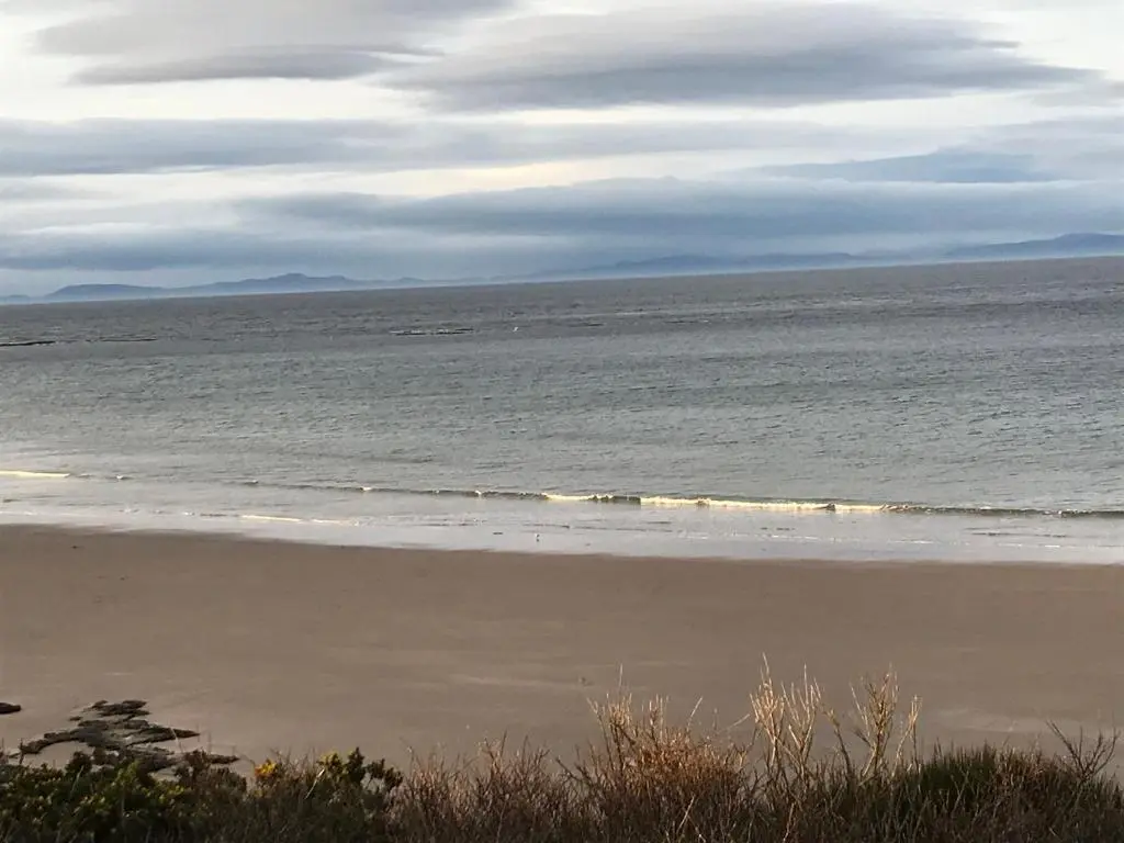 an empty beach with the ocean in the background at Covesea Lighthouse Cottages in Lossiemouth