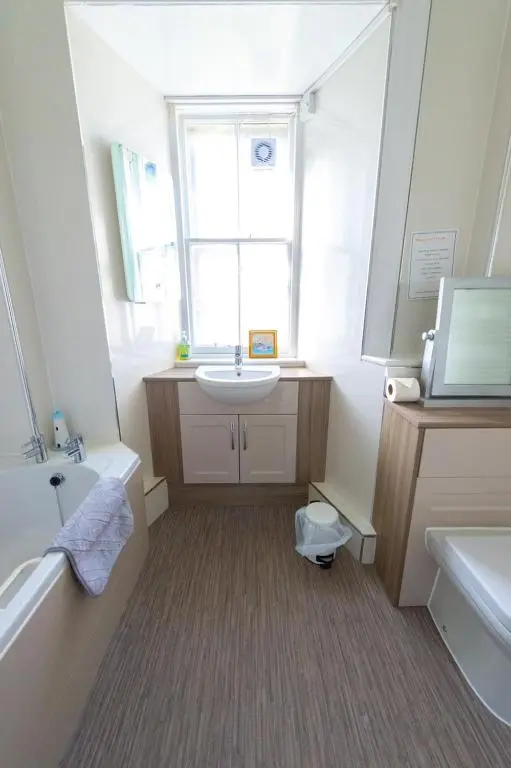 a bathroom with a sink and a tub and a window at Covesea Lighthouse Cottages in Lossiemouth