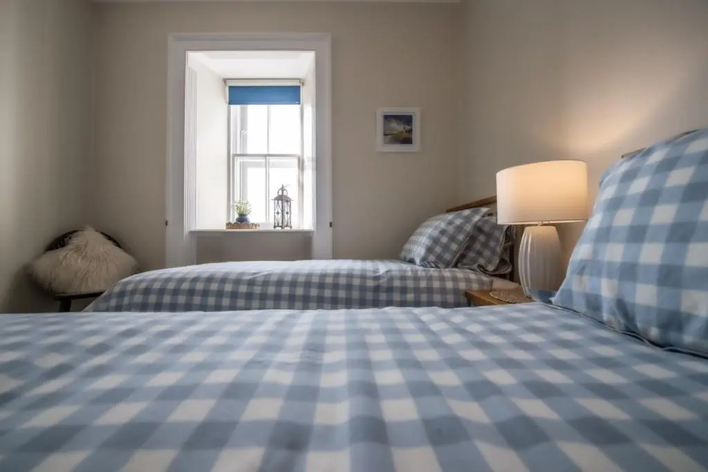 a bedroom with two beds and a window at Covesea Lighthouse Cottages in Lossiemouth