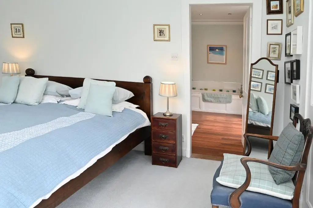 a bedroom with a bed and a chair and a mirror at Willowvale in Nairn