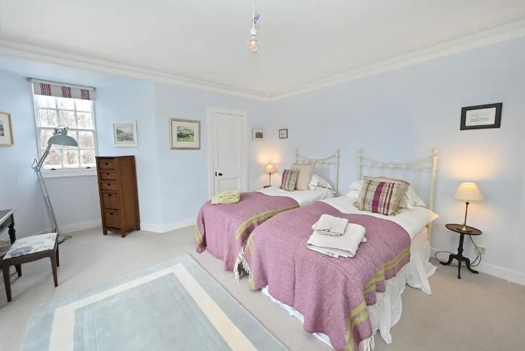 a bedroom with two beds with purple blankets at Willowvale in Nairn