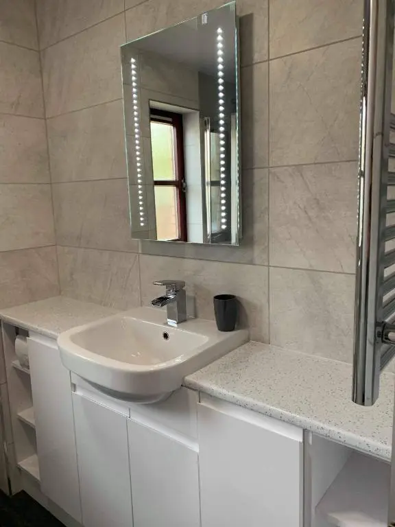 a bathroom with a sink and a mirror at Rendezvous , Aviemore in Aviemore