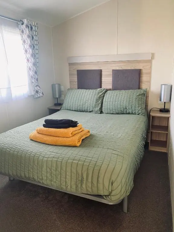 a bedroom with a bed with an orange towel on it at Paul\u2019s place silversands in Lossiemouth