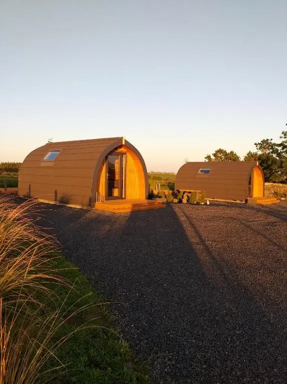 a couple of large buildings on a gravel road at North Star Glamping in Lybster