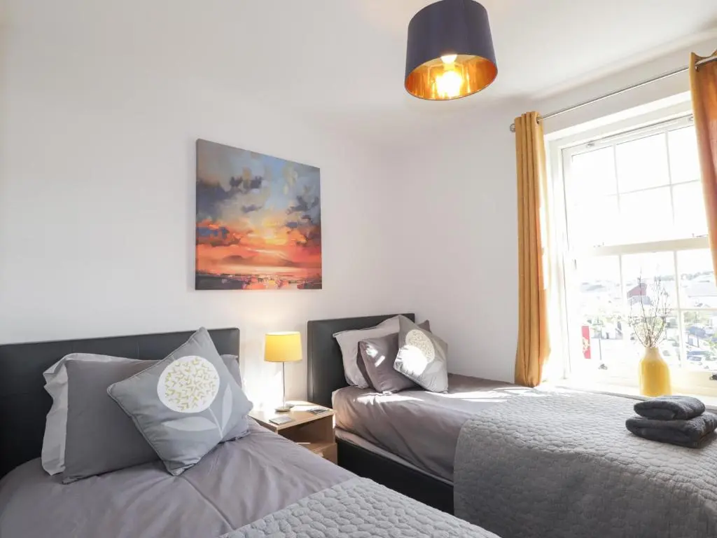 a bedroom with two beds and a window at The Nook in Inverness