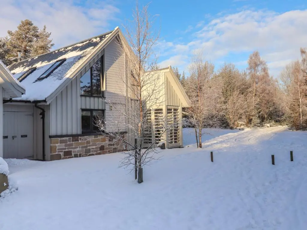 a house in the snow with a snow covered yard at Red Deer Lodge in Kingussie