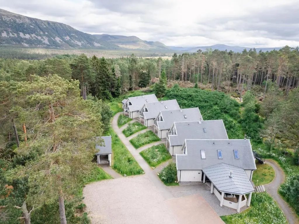an overhead view of a row of houses in the woods at Mountain Hare Apartment in Kingussie
