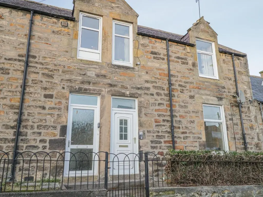 an old brick house with white doors and windows at The Neuk in Elgin