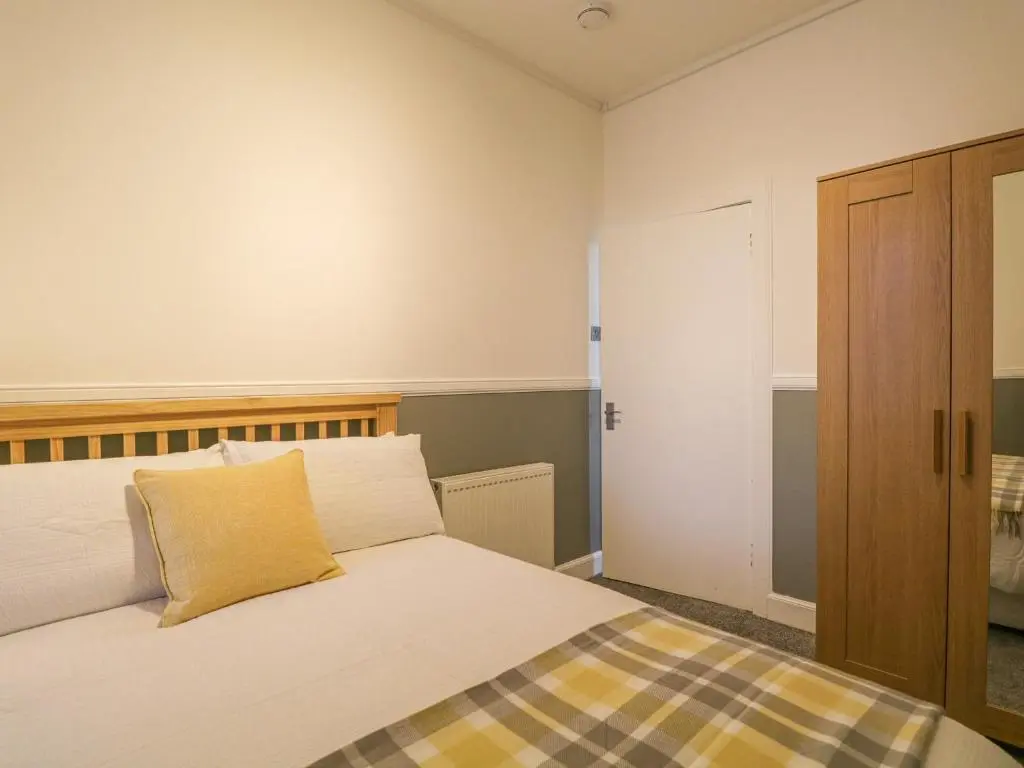 a bedroom with a bed with a yellow pillow on it at The Neuk in Elgin