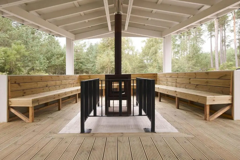 a large pavilion with benches and a table in the middle at Osprey Apartment in Kingussie