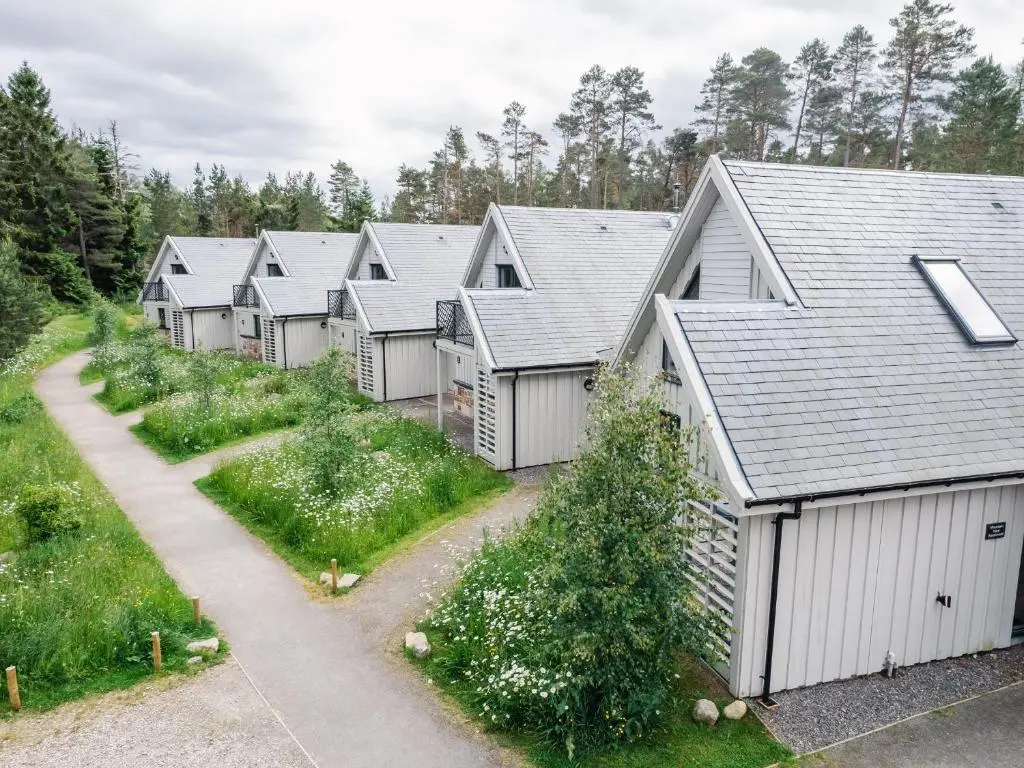 a row of houses in a row with a driveway at Osprey Apartment in Kingussie