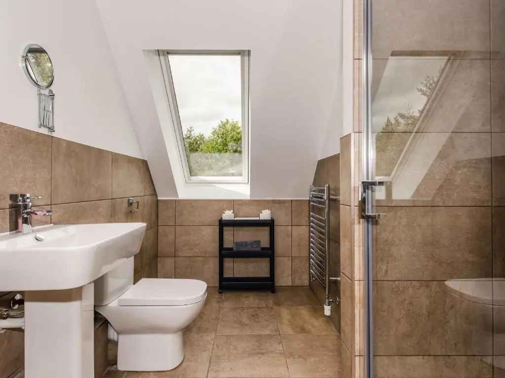 a bathroom with a toilet and a sink and a shower at Osprey Apartment in Kingussie