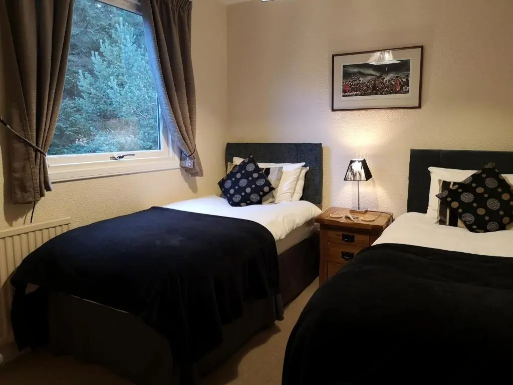 a bedroom with two beds and a window at Cranford Guest House in Braemar