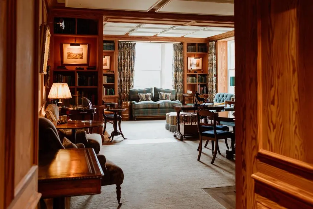 a living room with couches and tables and chairs at Links House at Royal Dornoch in Dornoch