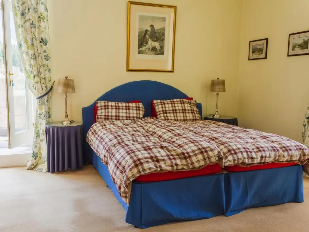 a blue bed in a bedroom with two lamps at Dalnaglar Castle - Uk7072 in Cray