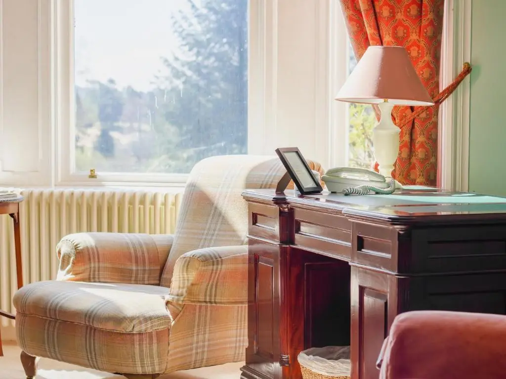 a room with a chair and a table with a lamp at Dalnaglar Castle - Uk7072 in Cray