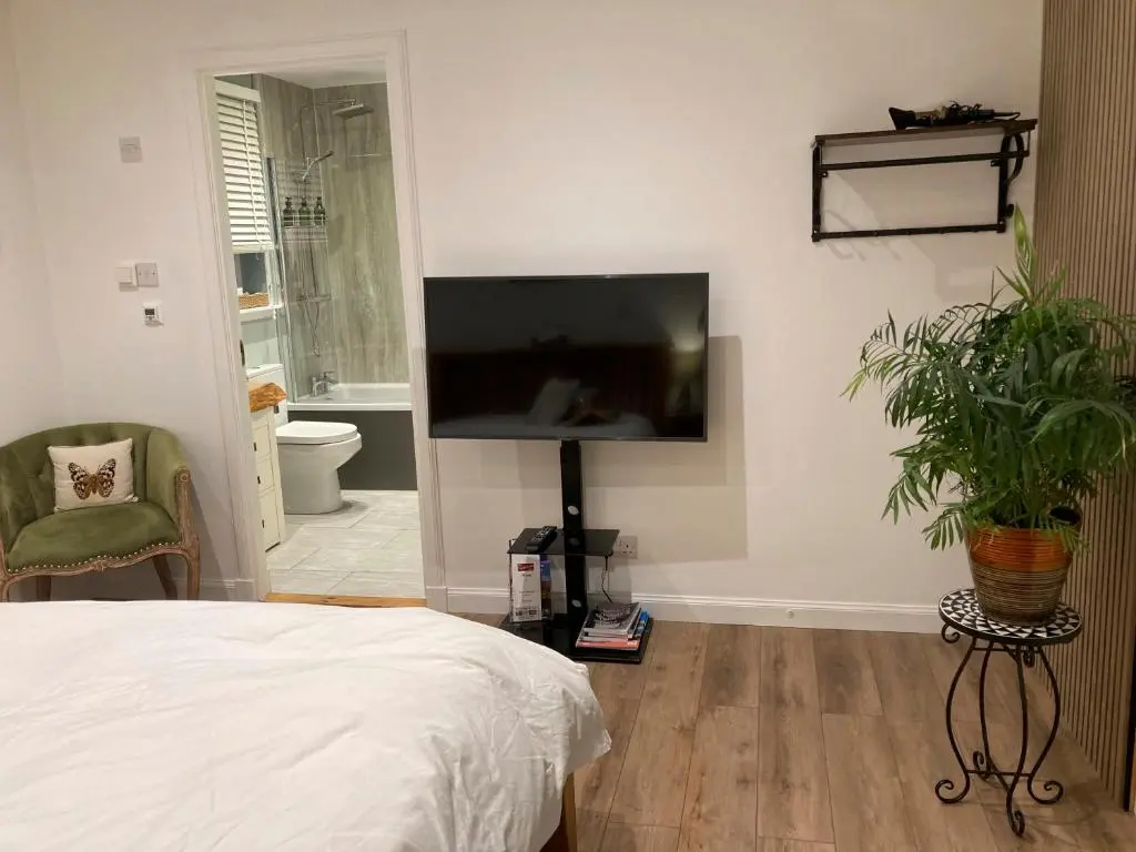 a bedroom with a flat screen tv on the wall at Clashmore Wood in Dornoch