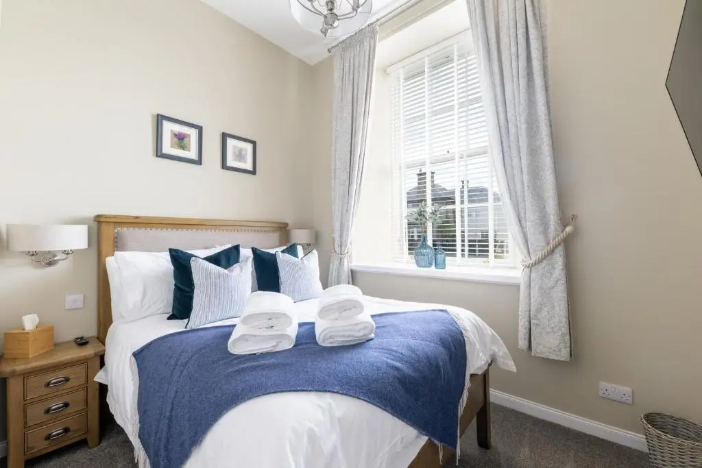 a bedroom with a bed with towels on it at Old Edinburgh Court in Inverness