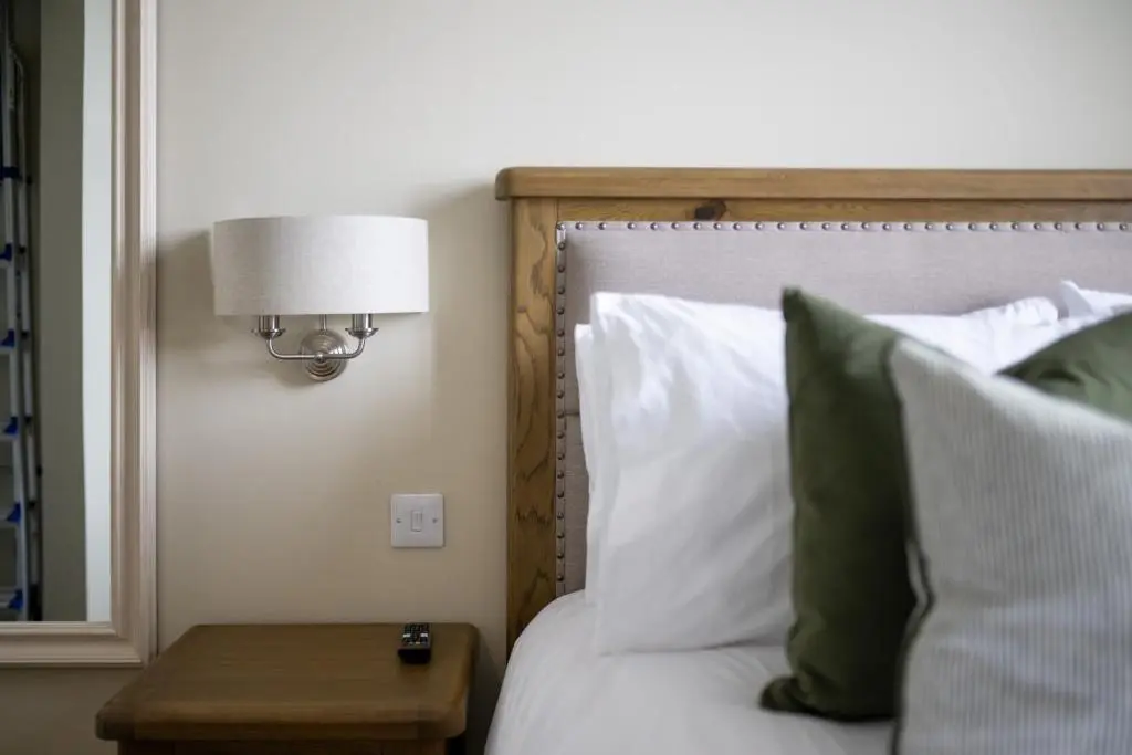 a bedroom with a bed with a lamp and a table at Old Edinburgh Court in Inverness