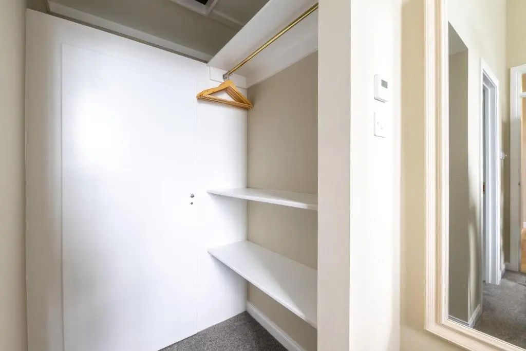 a walk in closet with white shelves and a window at Old Edinburgh Court in Inverness