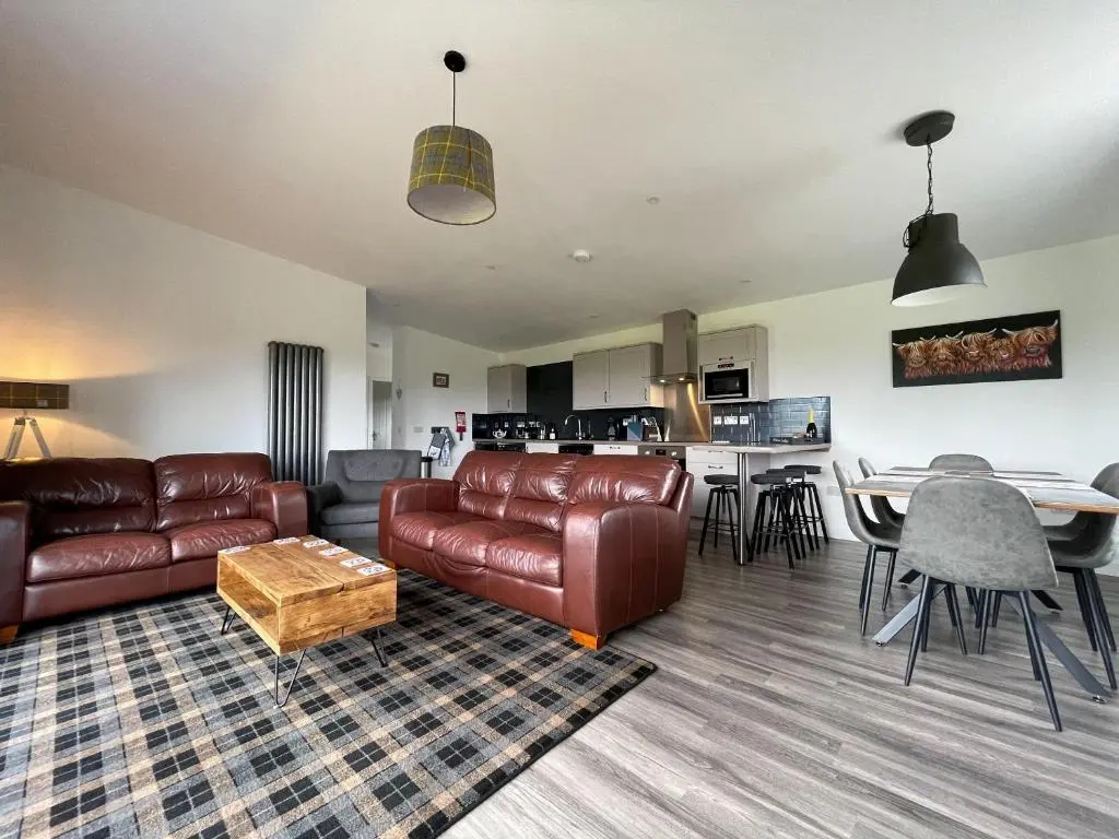 a living room with a couch and a table at Willow Lodge in Muir of Ord