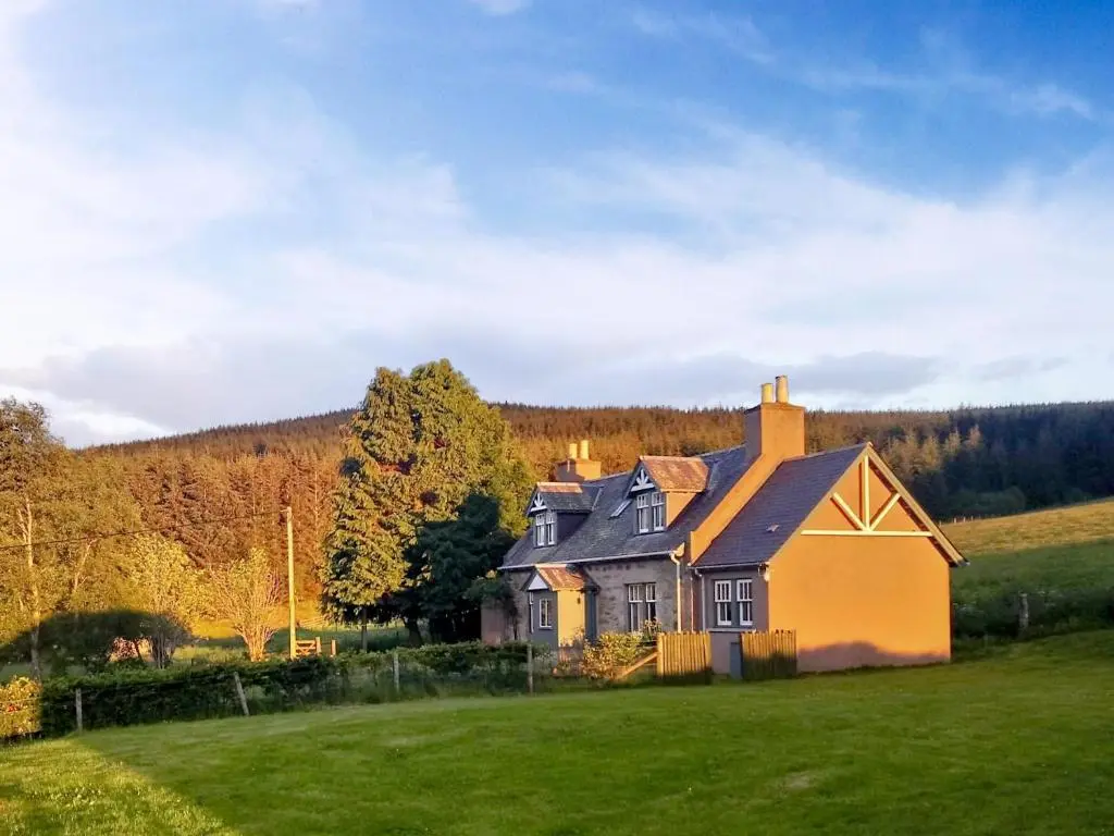 a house in the middle of a green field at Crofts in Badenyon