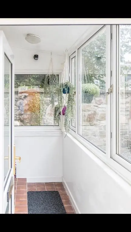 a room with two large windows and a rug at Lamont Cottage in Inverness