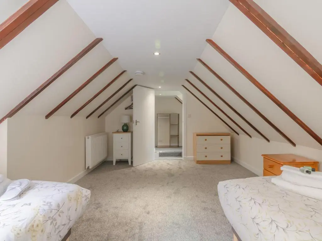 a attic bedroom with white walls and wooden beams at Dalnaglar Cottage - Uk30260 in Cray