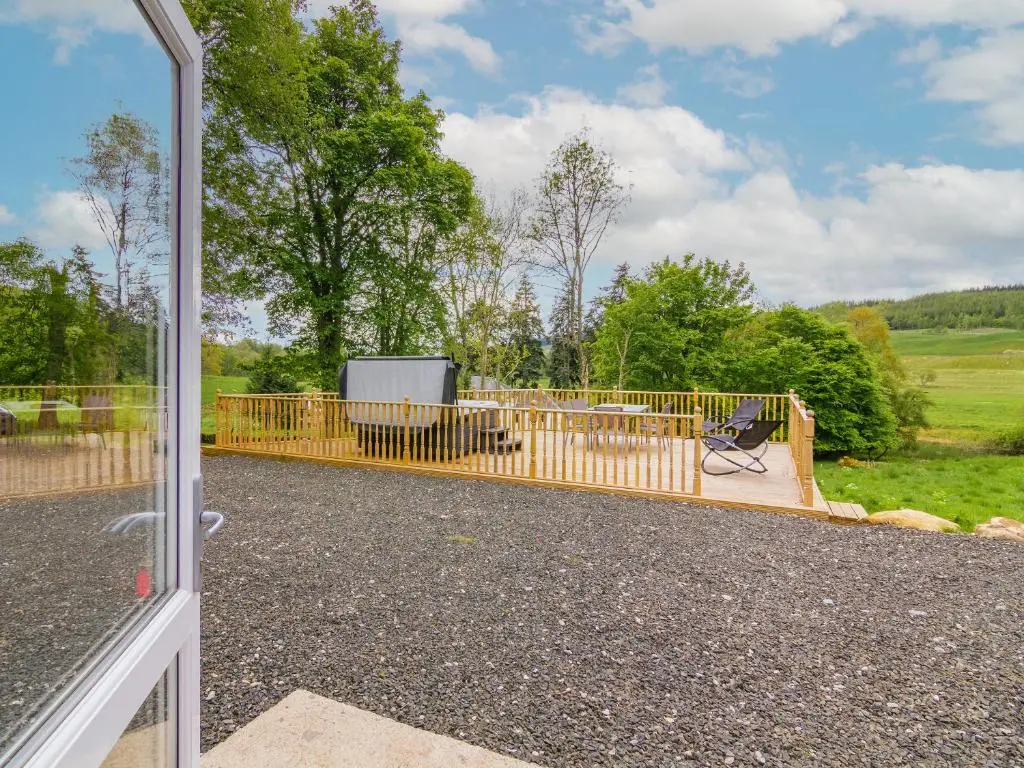 a view from a door of a patio with a fence at Dalnaglar Cottage - Uk30260 in Cray