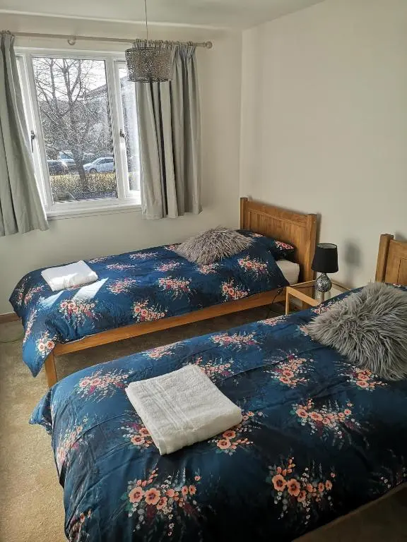 a bedroom with two beds and a window at Highland Home From Home in Inverness