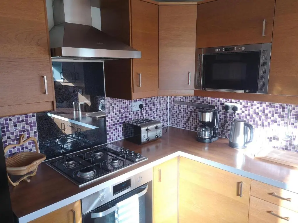 a kitchen with a stove and a counter top at Highland Home From Home in Inverness
