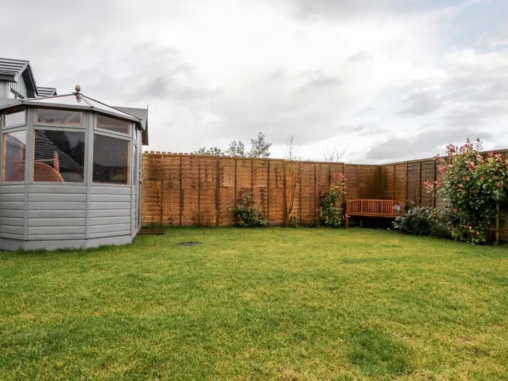 a small shed in a yard next to a fence at Skoglendi in Boat of Garten