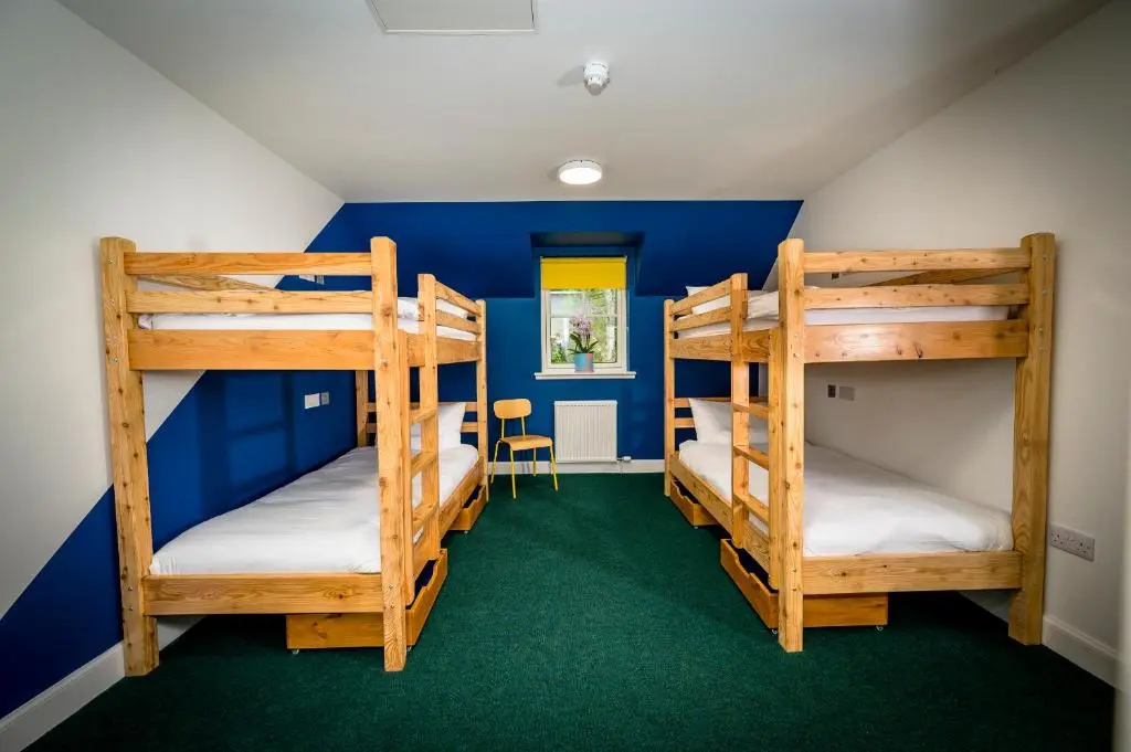 two bunk beds in a room with blue walls at Loch Ness Bunk Inn in Drumnadrochit