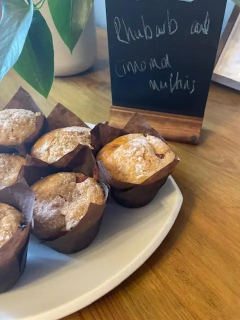 a plate of muffins on a table with a sign at Brooklynn Guest House in Grantown on Spey