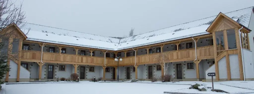 a large building with snow on the roof at Scandinavian Village Ltd in Aviemore