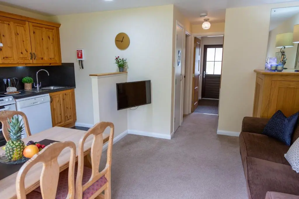 a kitchen and a living room with a table at Scandinavian Village Ltd in Aviemore