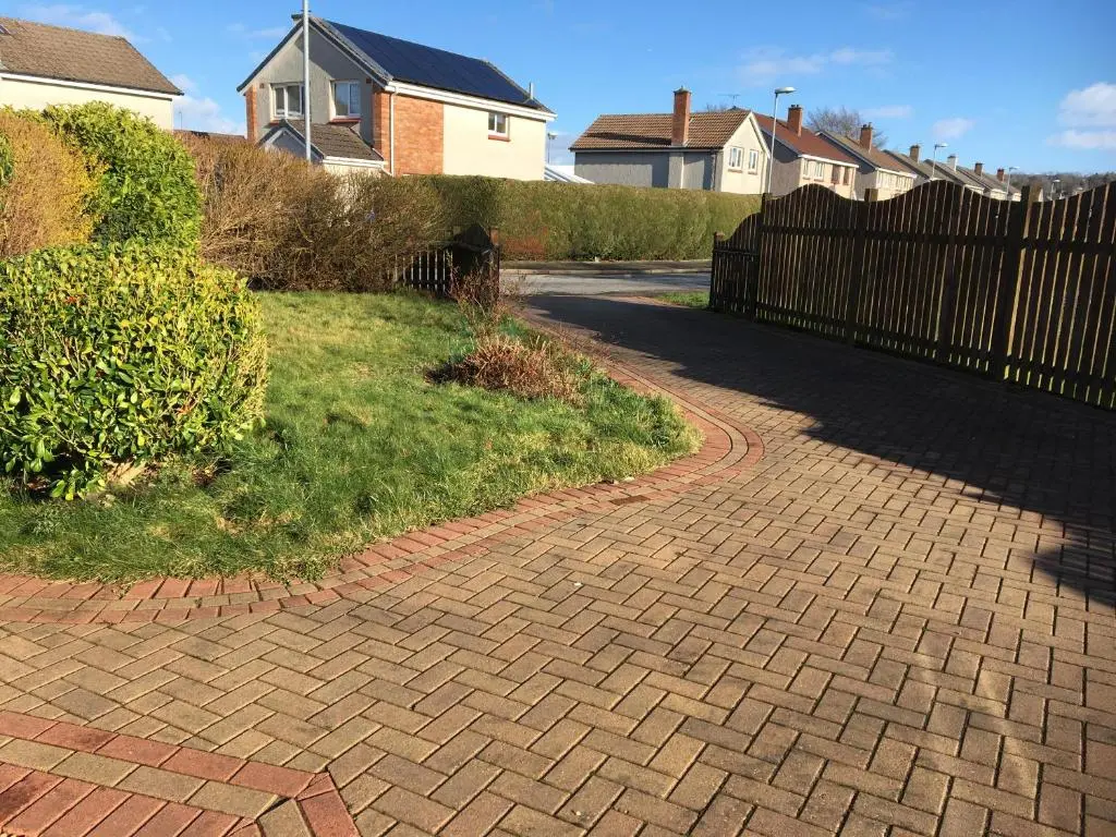a brick driveway with a fence and a house at Crescent Corner, Inverness in Inverness