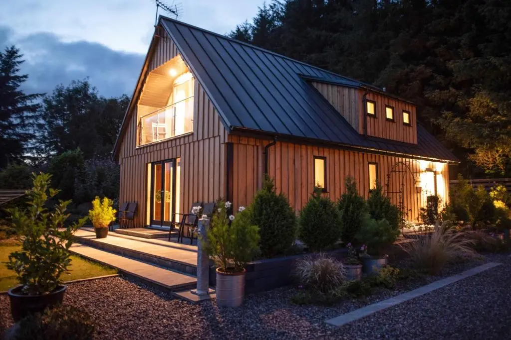 a wooden house with a gambrel roof at Larchwood Lodge in Ellon