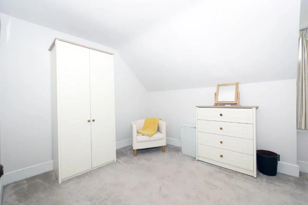 a white bedroom with a mirror and a white dresser at Ardentorrie Holiday Home in Inverness