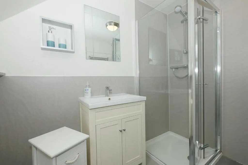a white bathroom with a shower and a sink at Ardentorrie Holiday Home in Inverness