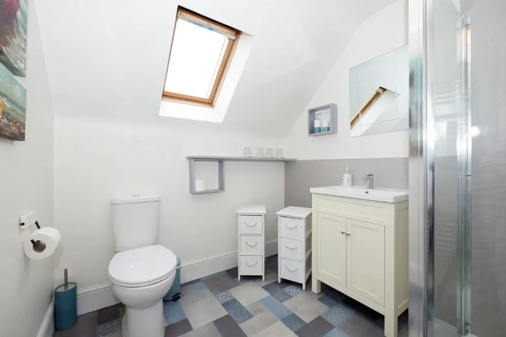 a white bathroom with a toilet and a sink at Ardentorrie Holiday Home in Inverness