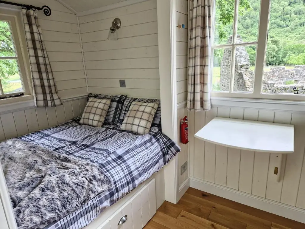 a small room with a bed and a window at Craskie Glamping Pods in Inverness