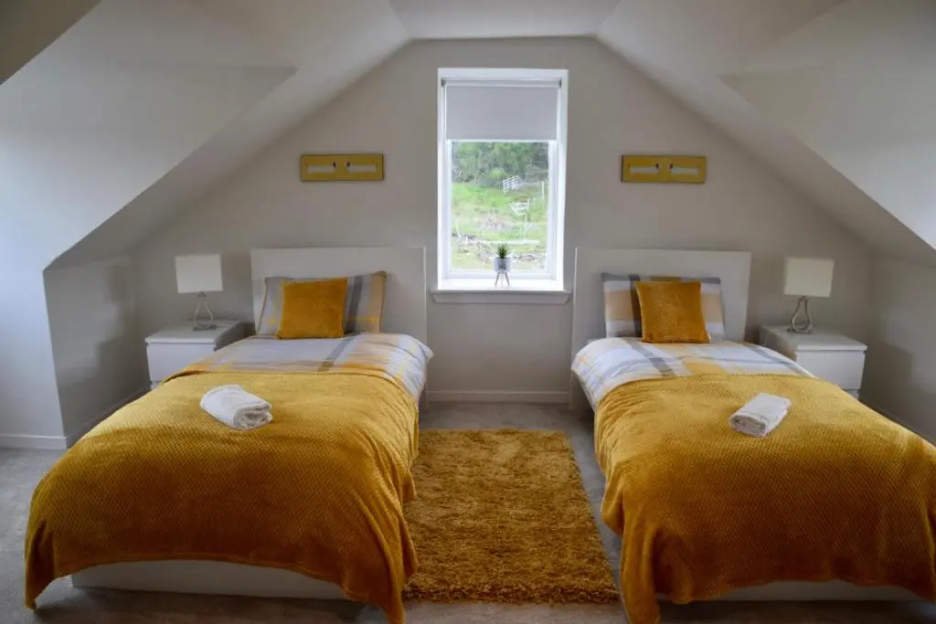 two beds in a attic room with a window at Balintombuie in Dalchreichart