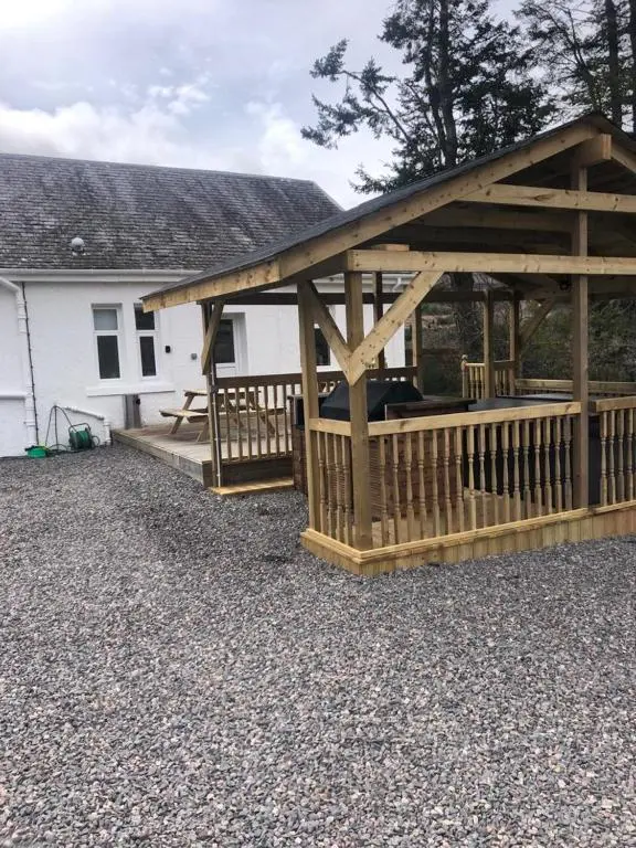 a wooden gazebo in front of a house at Balintombuie in Dalchreichart