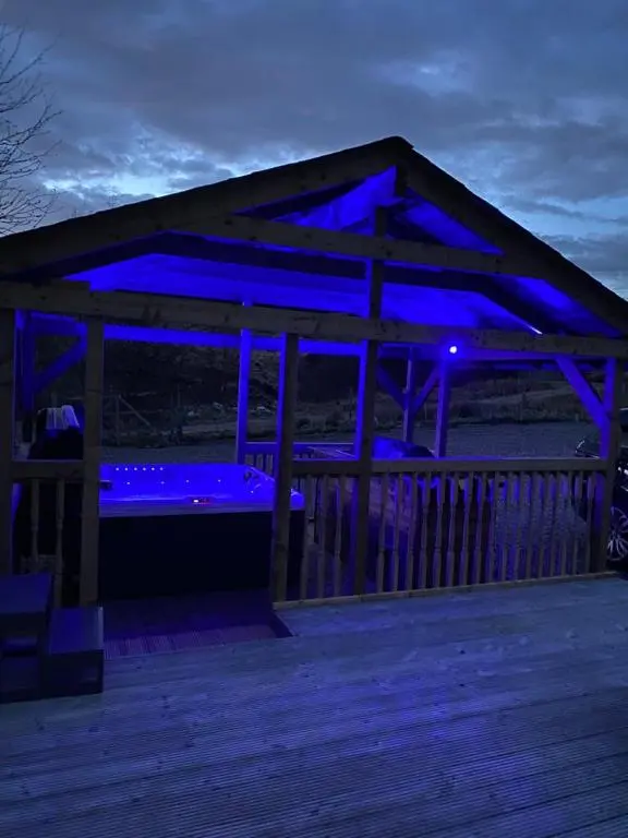 a blue lit up gazebo on a deck at night at Balintombuie in Dalchreichart