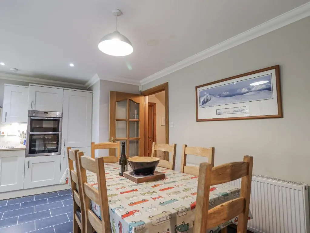 a kitchen and dining room with a table and chairs at Burnside House in Aviemore