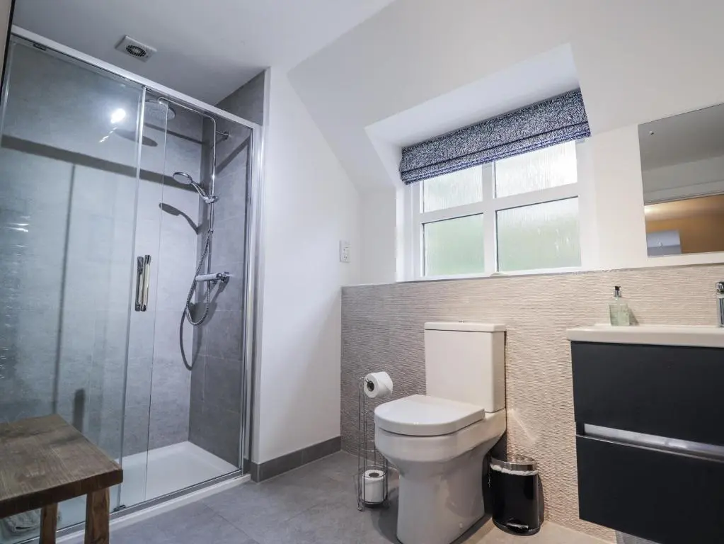 a bathroom with a shower and a toilet and a sink at Burnside House in Aviemore