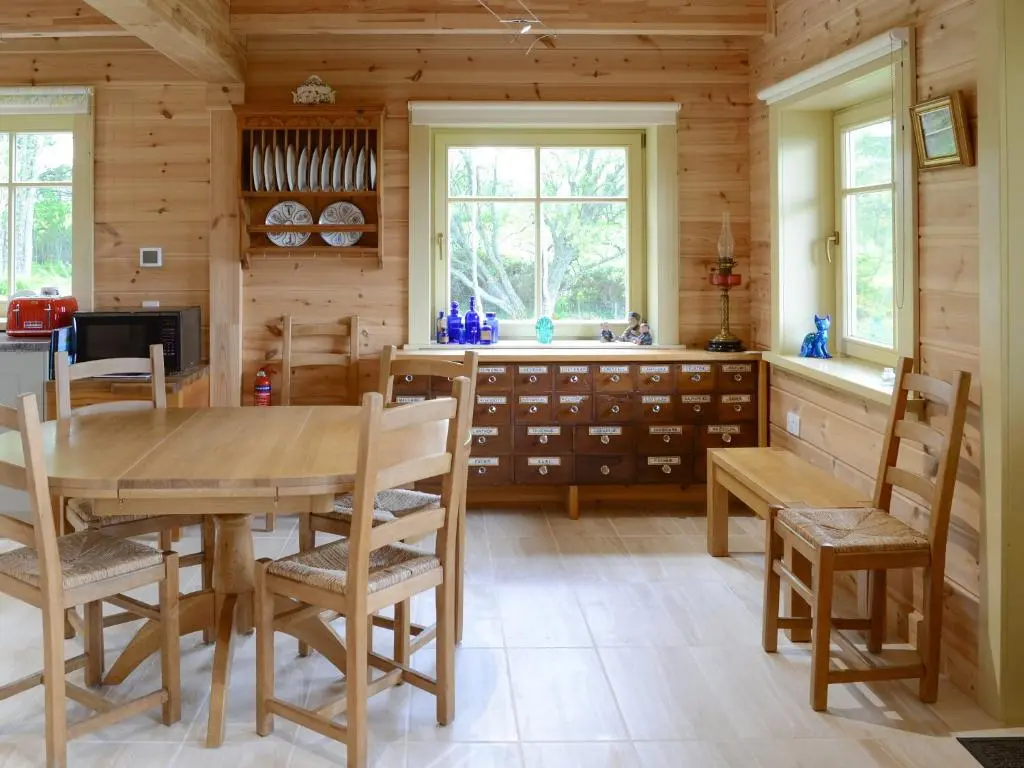 a dining room with a wooden table and chairs at Moonshine Cottage in Culbokie