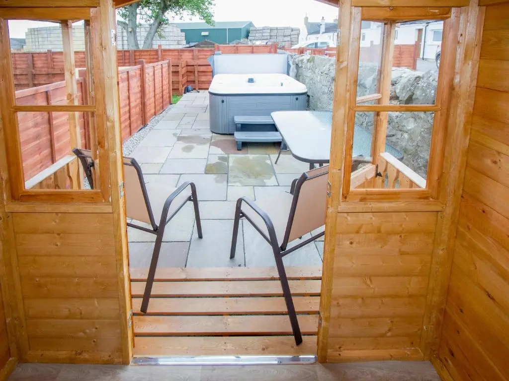 a screened in porch with a table and chairs at Grieve's Cottage in Portmahomack