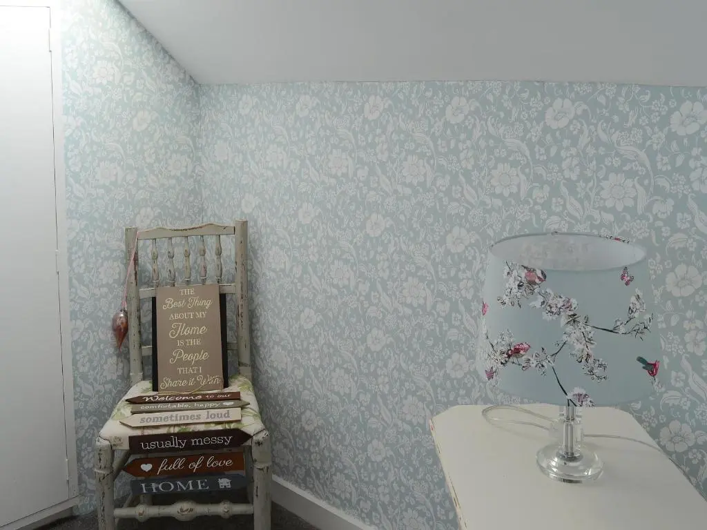 a room with a table with a lamp and books at Sea Thistle Cottage in Nairn